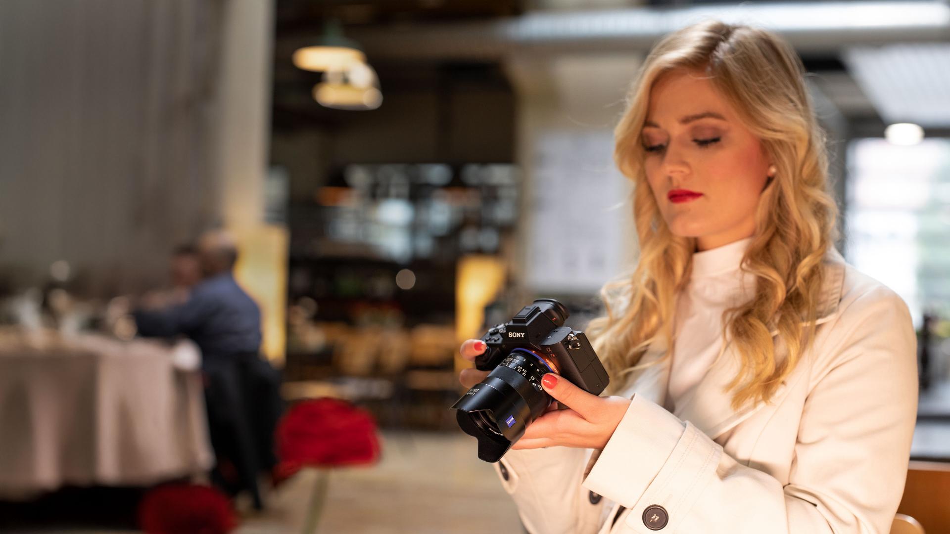 A focused individual holds a camera equipped with a ZEISS lens, embodying the passion for photography and the precision of ZEISS optics.