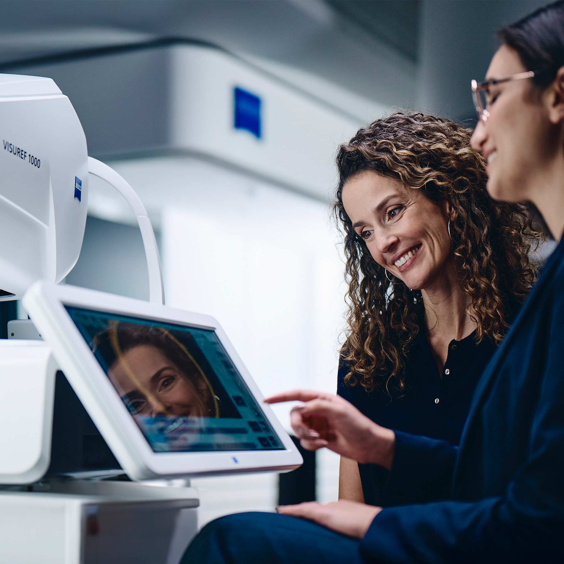 Twee vrouwen die kijken naar het beeldscherm van de ZEISS VISUREF 1000.