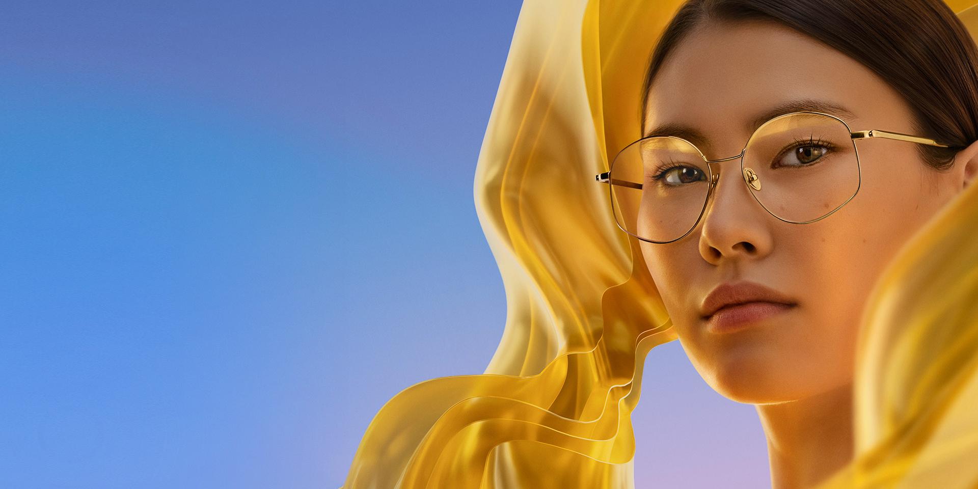 Een vrouw die een bril draagt met heldere glazen met ZEISS DuraVision Gold UV, waardoor de brillenglazen een subtiele maar kenmerkende goudkleurige glans krijgen.
