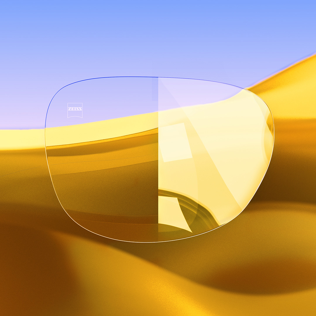Een afbeelding met een gedeeld brillenglas waarvan de ene helft helder en schoon is dankzij ZEISS DuraVision Gold UV, terwijl de andere helft sterke spiegelingen laat zien. 