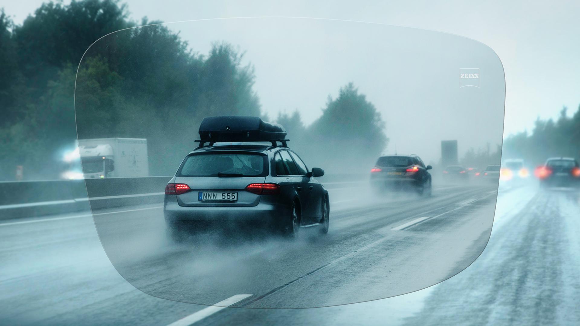 Zicht door een ZEISS DriveSafe Unifocaal brillenglas op de snelweg op een regenachtige dag 