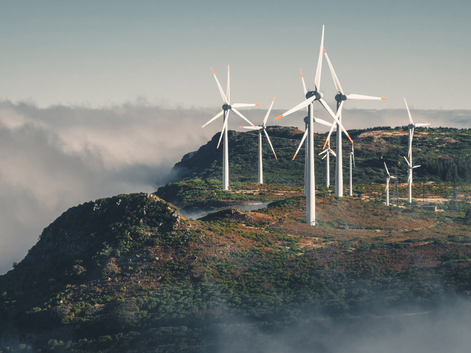 Een afbeelding van windturbines op een klif. 