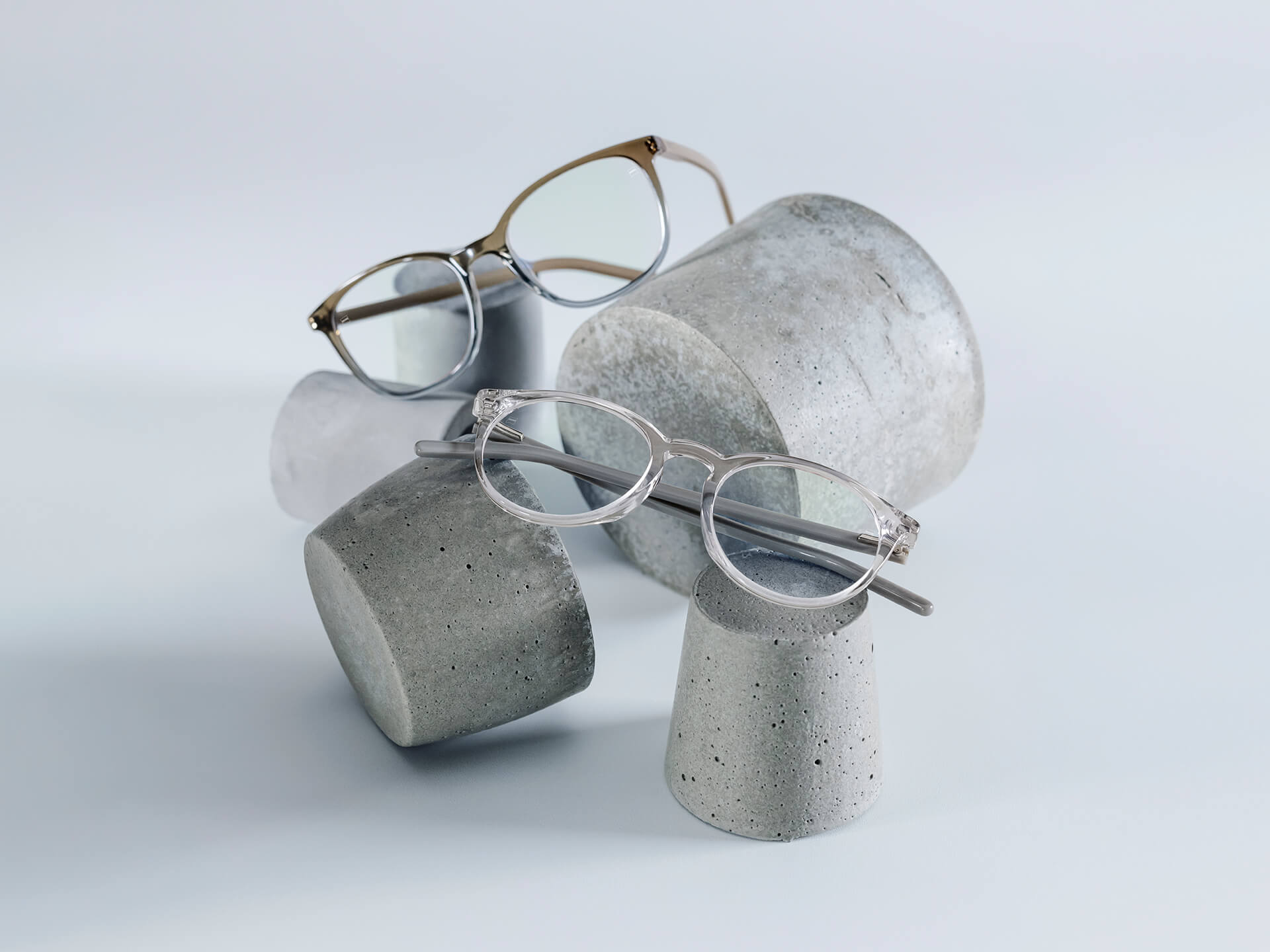 Bril met ZEISS brillenglazen die voorzien zijn van DuraVision® Chrome coatings worden op stenen sokkels van verschillende grootte geplaatst.