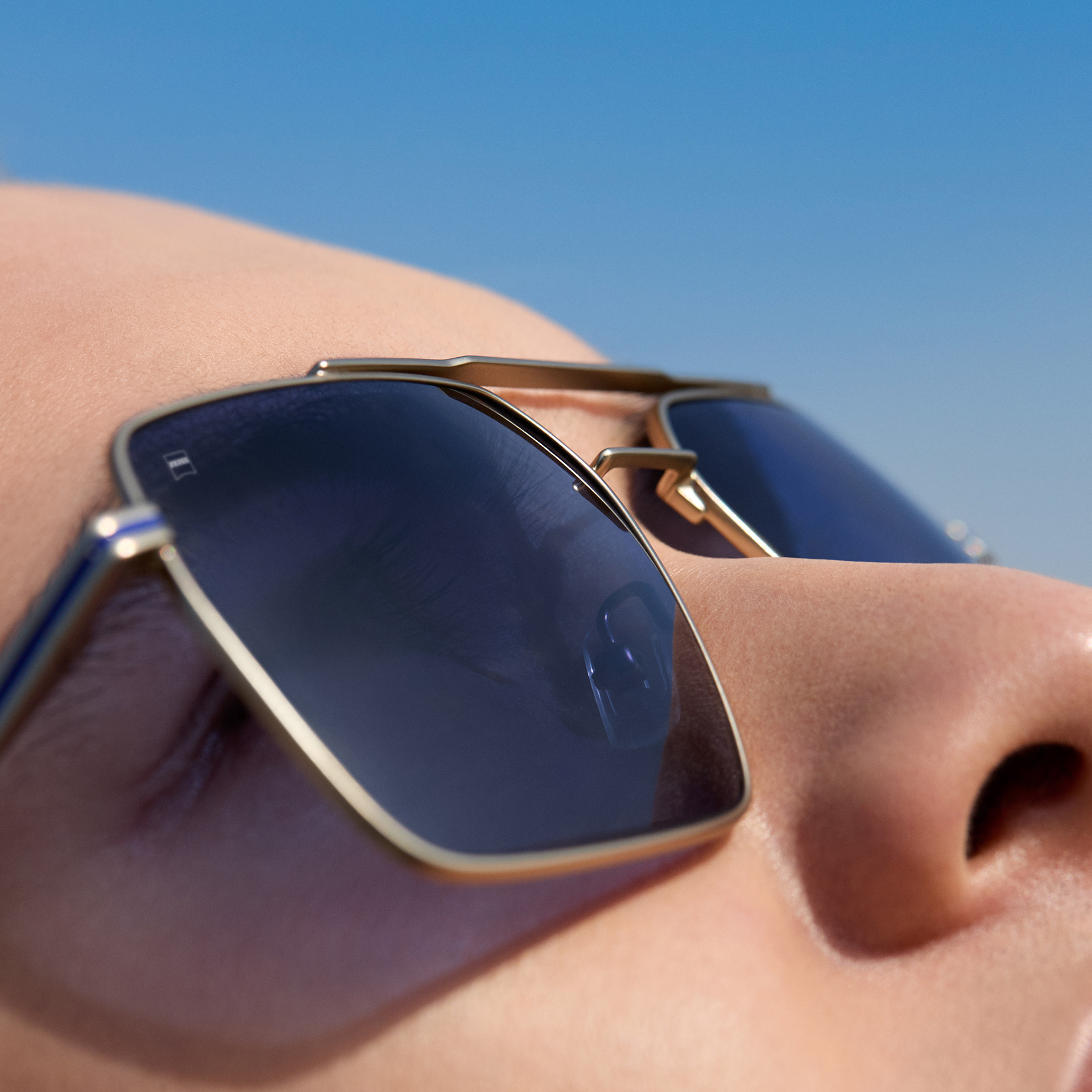 Een close-up van een man die ZEISS zonnebrilglazen op sterkte draagt in de kleur Midnight Blue. 