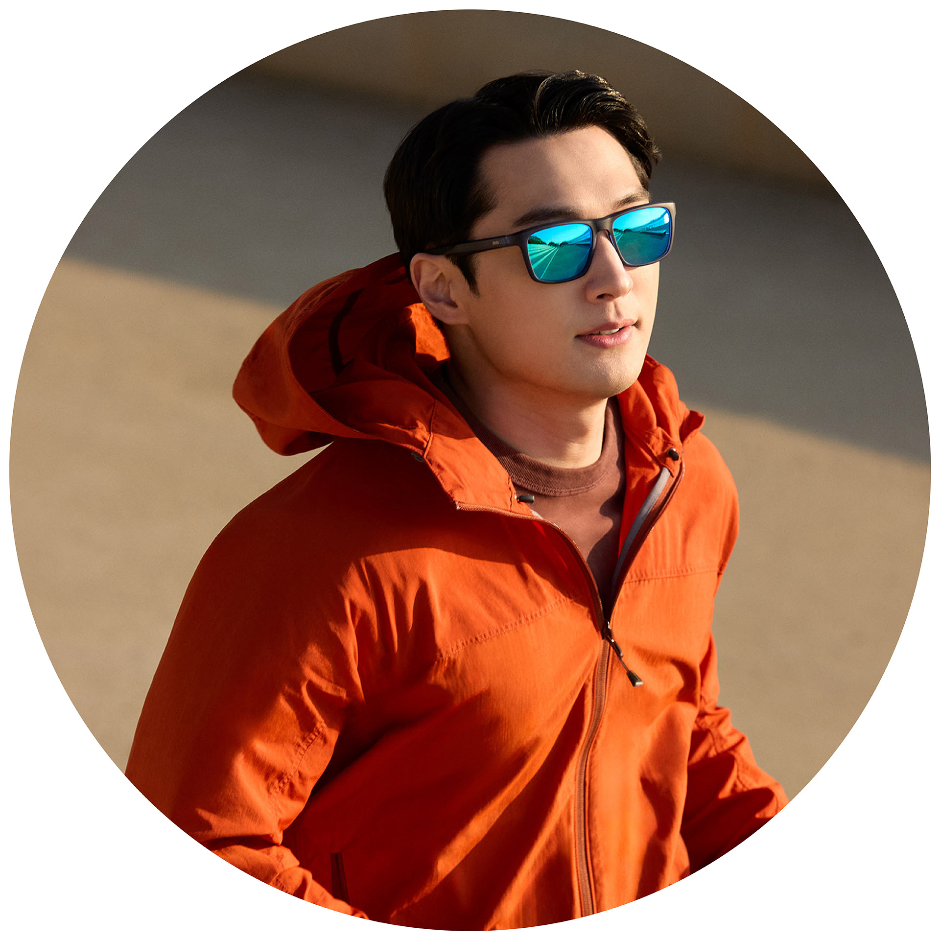 Een jogger in een oranje jack met ZEISS zonnebrilglazen op sterkte met een blauwe spiegelcoating.