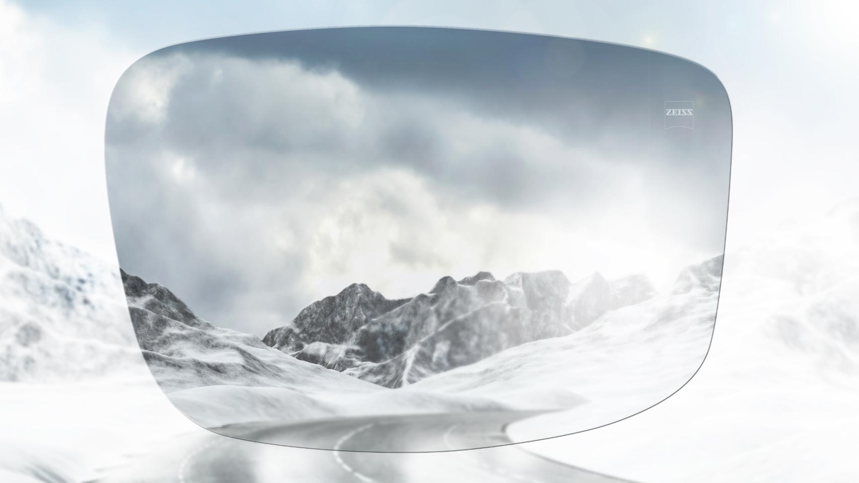 Zicht op een besneeuwde bergweg met en zonder gepolariseerde glazen. Met een gepolariseerde zonnebril wordt schittering verminderd voor een veel duidelijker zicht vooruit.