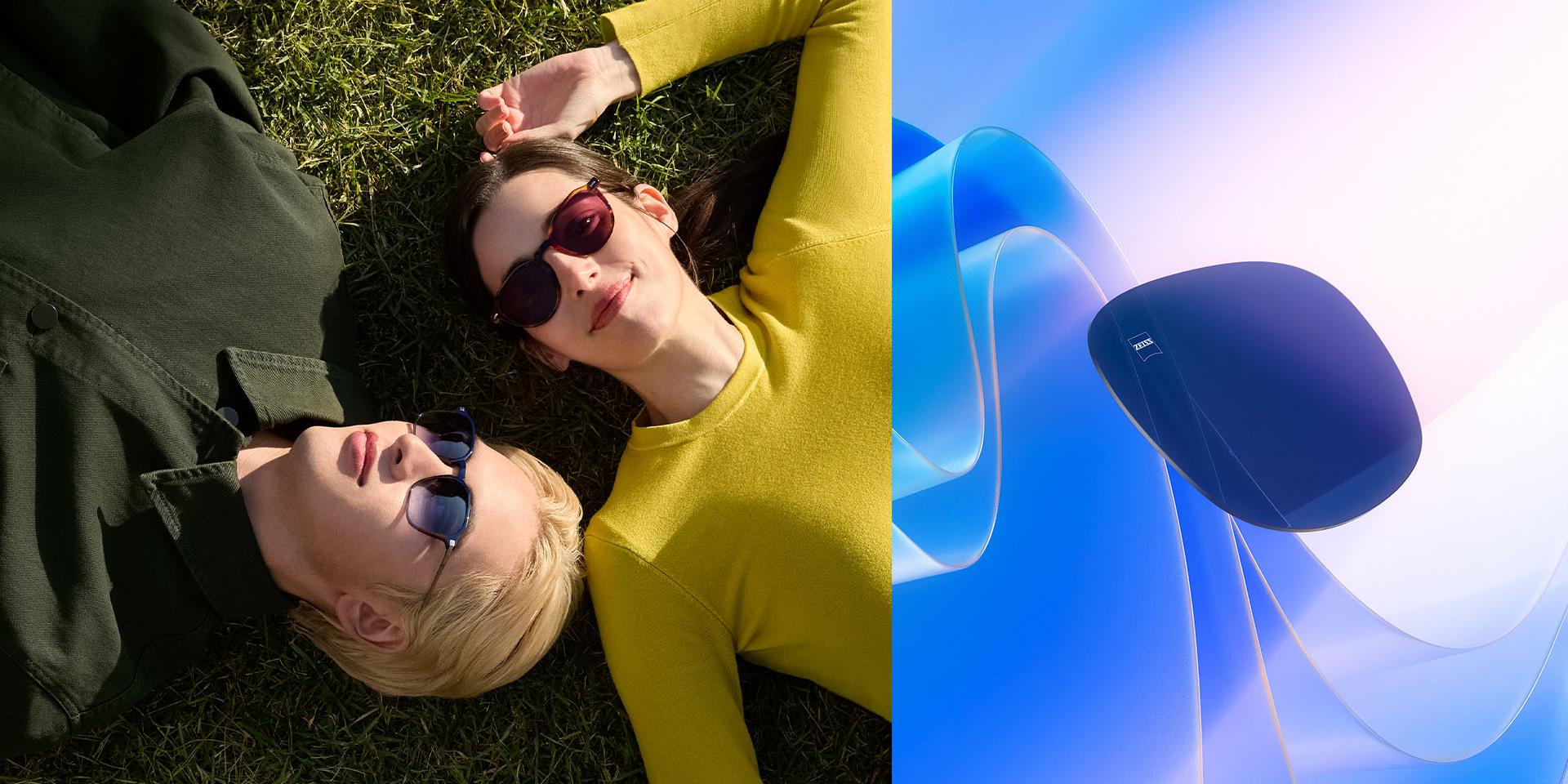 Man en vrouw met een zonnebril op sterkte op de neus, die aan het ontspannen zijn op het gras en naar de lucht kijken. Een CGI-illustratie dat een gekleurd brillenglas laat zien dat richting de zon zweeft, waarmee de UV-blokkerende functie van het glas wordt gesymboliseerd