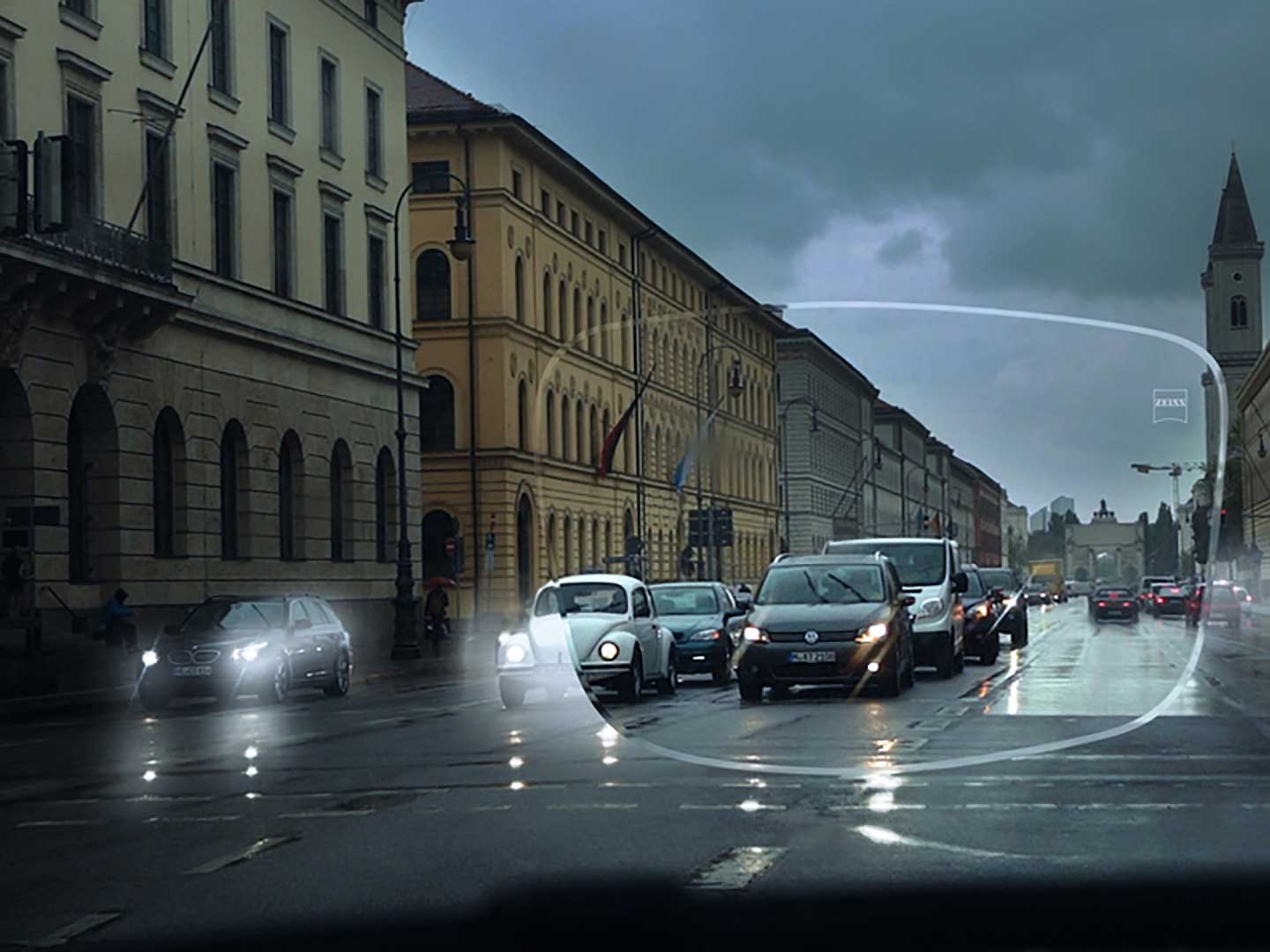 De afbeelding toont slecht zicht bij weinig licht op straat. Het zichtpunt is vanuit het interieur van een auto, gezien door een brillenglas. 