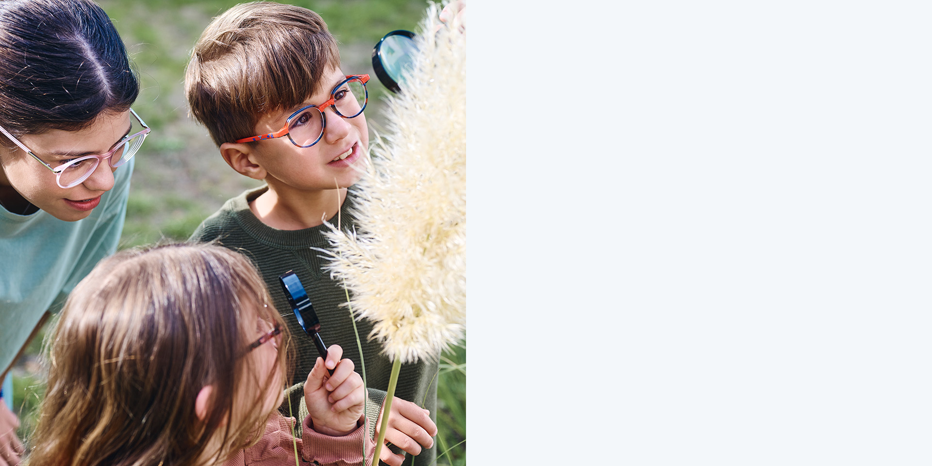 2 meisjes en 1 jongen dragen ZEISS MyoCare brillenglazen. Ze kijken naar een plant, twee van de drie kinderen bekijken de plant door een vergrootglas.