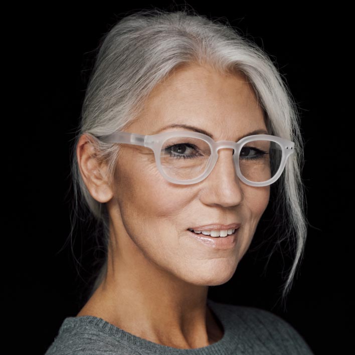 Vrouw met grijs haar draagt een wit montuur met ZEISS progressieve SmartLife brillenglazen. Geometrische gezichtsscan met gezichtsanatomie en montuurmetingen.